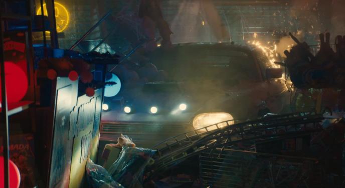 a car with its headlights on in a junkyard workshop