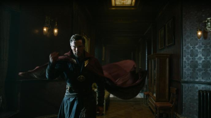 doctor strange wearing the cloak of levitation as it floats behind while he is walking down the hallway