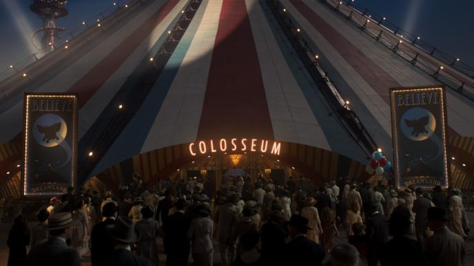 colosseum tent from the dreamland fun fair lit up as a crowd of people walk toward the entrance