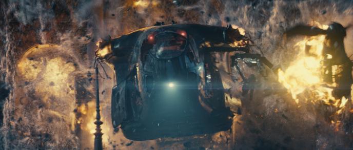 front view of a helicopter blown to pieces engulfed in fire in front of an explosion