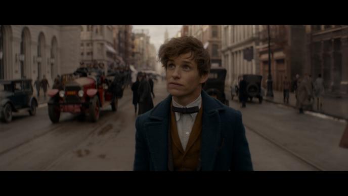 actor eddie redmayne as newt scamander character walking through a street