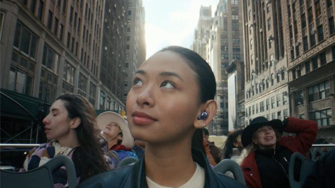 a woman looking up out of a full open top bus