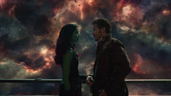 guardians of the galaxy characters gamora and star-lord looking at each other while standing at a balcony that overlooks the cosmos