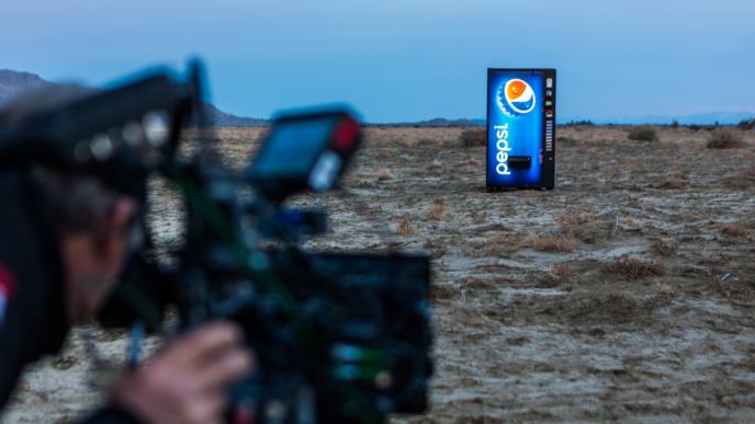 a cameraman taking a shot of a pepsi branded vending machine