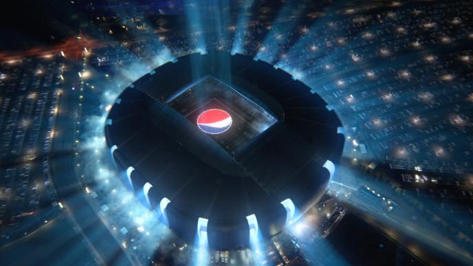 a brightly lit up ufo stadium that has the pepsi logo in the field area