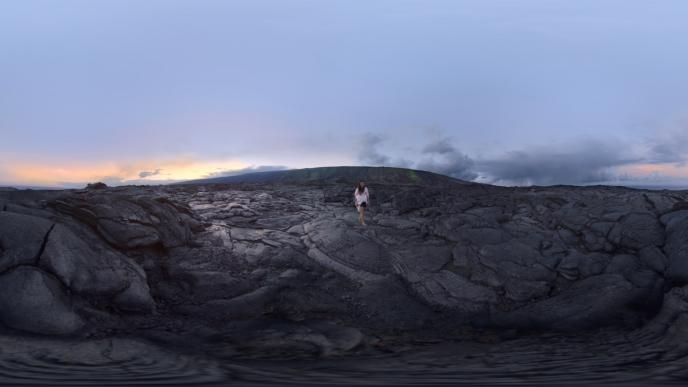 a woman walking through hawaiian volcanic mountains