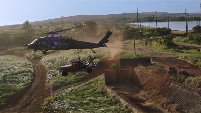 a helicopter mid air pulling up a pick-up truck in hawaii