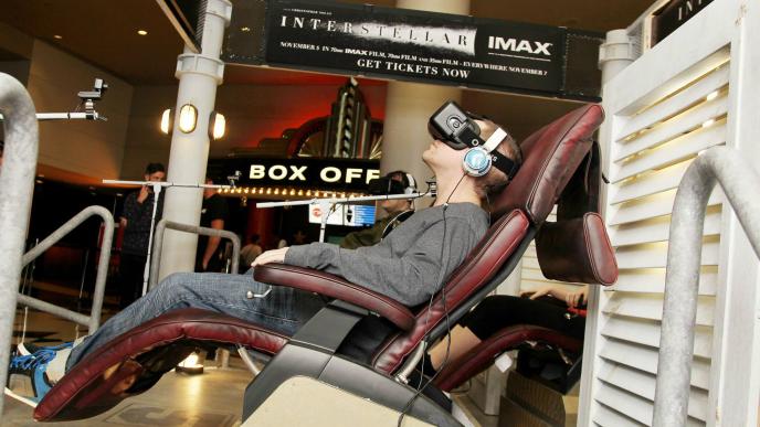 side view of a man sitting in a chair wearing a vr headset