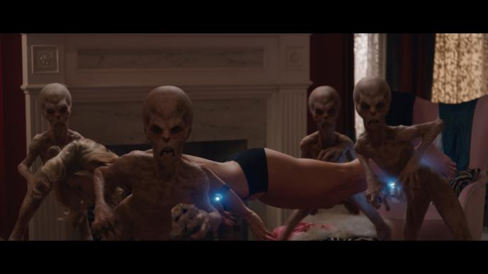 four keeper aliens angrily looking at the camera as a woman hovers face down mid air between them