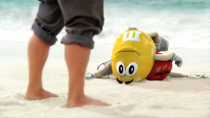 cg animated yellow m&m on top of the red m&m at the beach as a persons legs are peaking