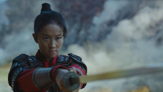mulan actress liu yifei holding a sword with both hands, pointing it at the enemy while staring directly at them