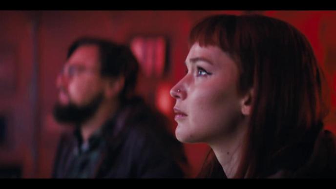 side view of two characters from dont look up staring up at a screen