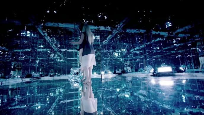 a woman walking through a mirrored immersive exhibition