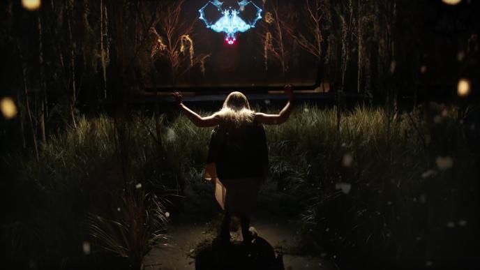 a woman walking through an immersive exhibition