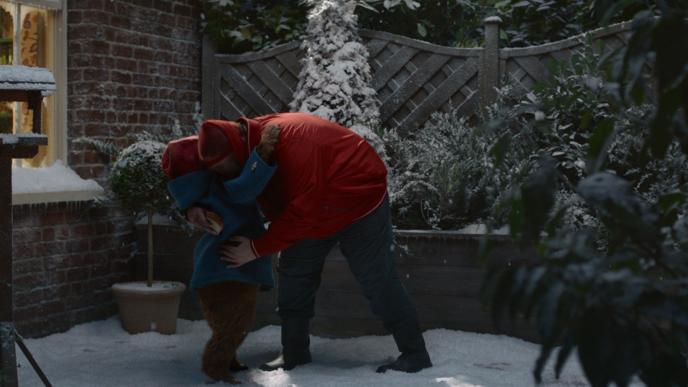 cg animated paddington bear hugging someone as they hold on to a sandwich