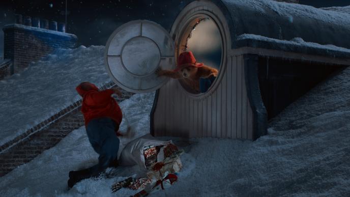 animated paddington bear coming out of a window on a snowy roof