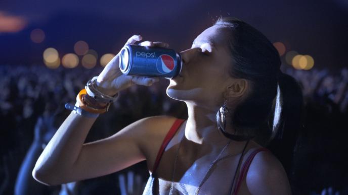 woman drinking a can of pepsi in a concert