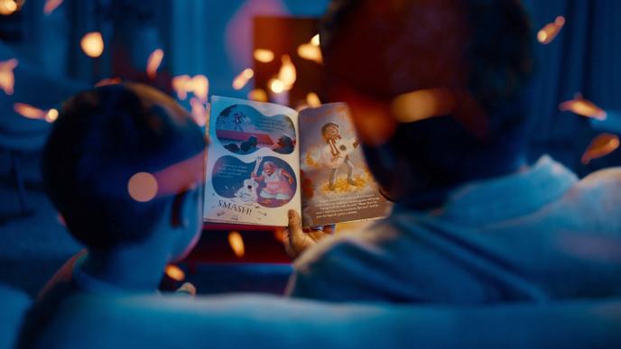 back view of a father and son reading a bedtime story