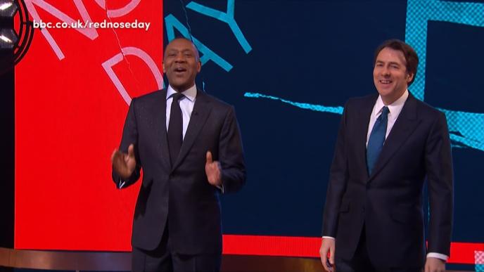 hosts wearing suits on a stage