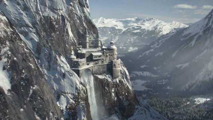 mountain-side castle shirburn castle with a water fall covered in snow