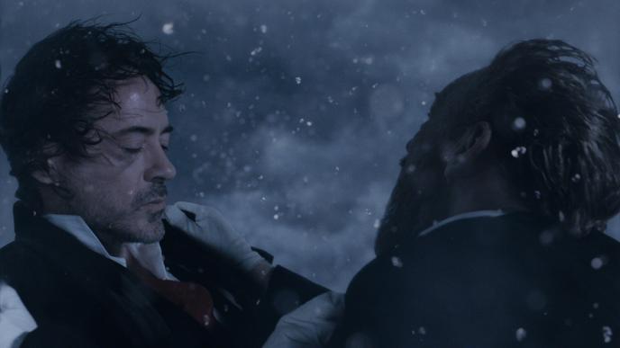 actor robert downey jr as sherlock holmes with his eyes closed as actor jude law as john h watson holds onto him