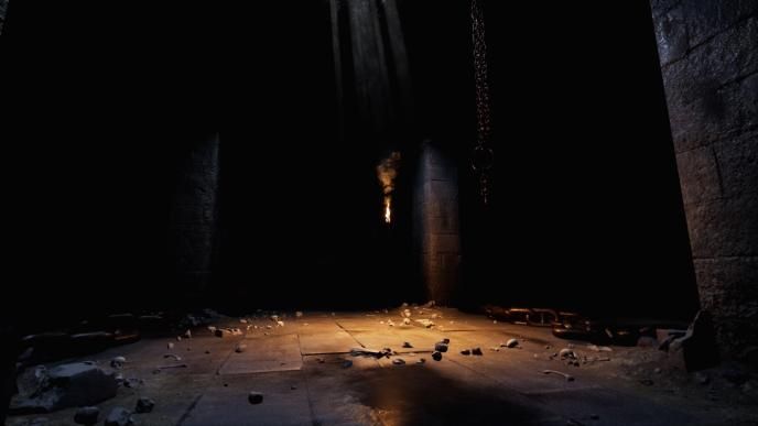 an animated dimly lit dungeon that is covered in rubble and human bones