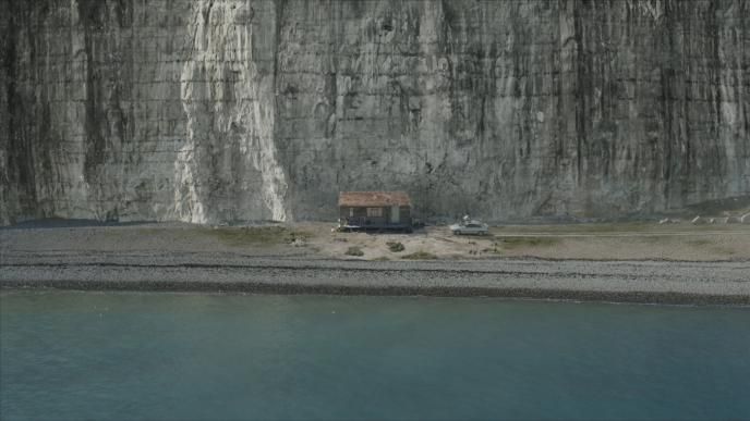 a seaside cabin house in front of a cliff