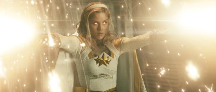 actor erin moriarty as annie january character holding arms up with whitened eyes as light surrounds her