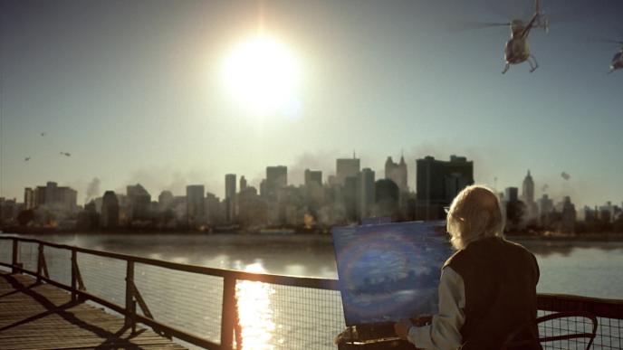 an elderly man painting the city from across the river as the city is set aflame. there are helicopters circling the city