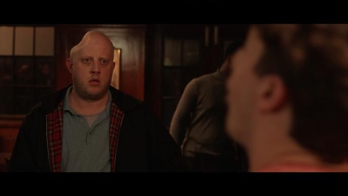 a man with his head caved in looking at a person in front of him