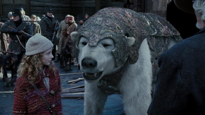 actress dakota blue richards as lyra belacqua standing next to panserbjorn polar bear iorek byrnison who is speaking to her