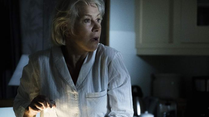 actress helen mirren wearing white pyjamas looking to her right with a shocked expression on her face