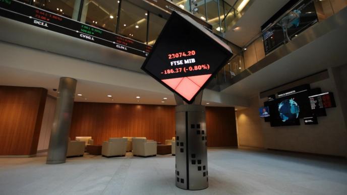 a cube screen attached to a tower that has the stock exchange projected on it