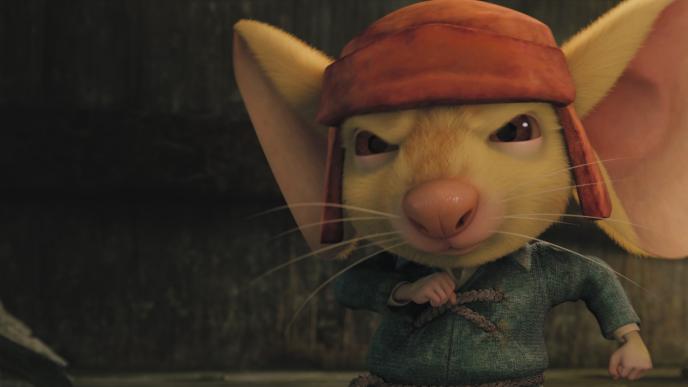 close up of despereaux wearing a red hat and blue jumper holding up an arm looking determined