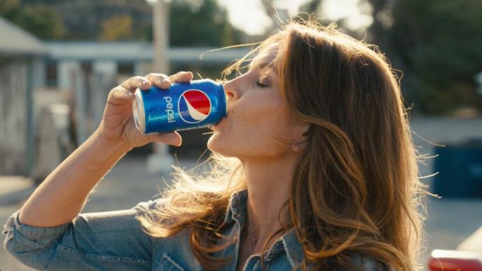 a person drinking a can of pepsi