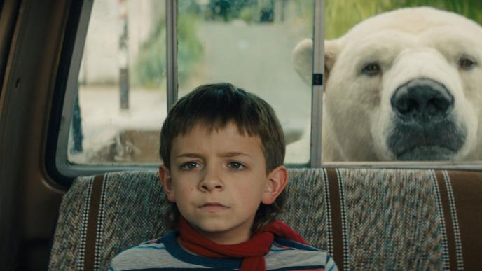 timmy failure sitting at the back of a car with his polar bear friend peaking its head through the window at the back