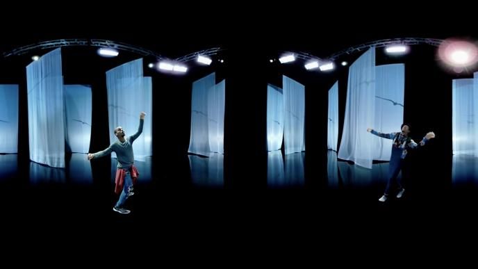two dancers dancing in front of full length sheets that have art projected onto them