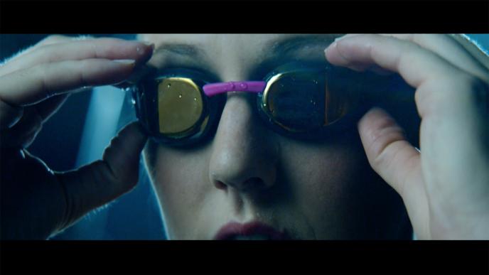 close up of a swimmer's face adjusting swimming goggles