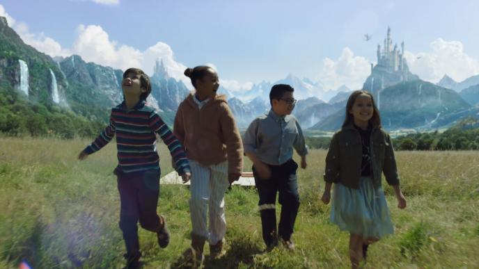four children walking and smiling through a magical meadow