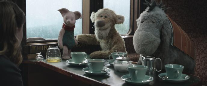 Eeyore, Tigger and Piglet sit at a table in a train carriage