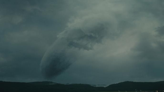 enormous spacecraft hovering in the atmosphere in a silhouette of clouds