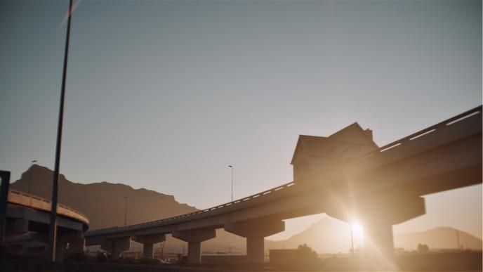 ground perspective of a house on an elevated bridge railway in golden hour
