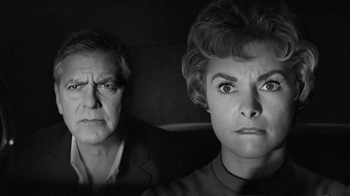 a black and white close up of george clooney and janet leigh as marion clane driving in a car