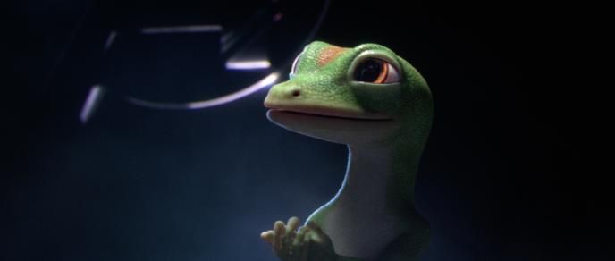 close up of the geico gecko looking towards the left in front of a dark background
