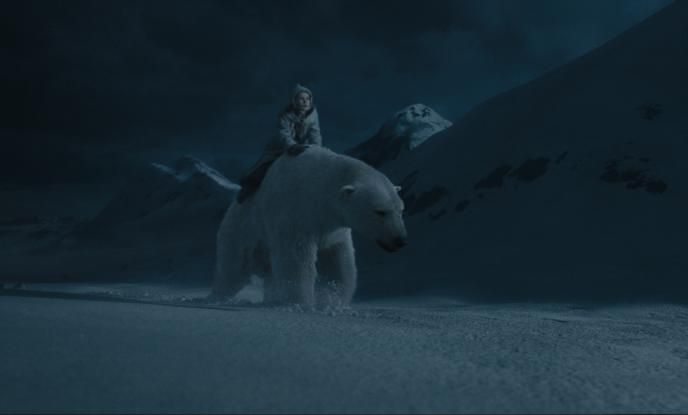 lyra belacqua sitting on iorek byrnisson walking through snow