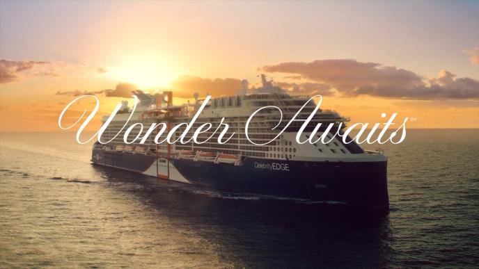 a cruise ship sailing through the ocean during sunset. text 'wonder awaits' is in the centre of the image