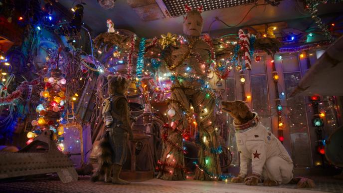 Rocket and Cosmo decorate Groot as a Christmas tree