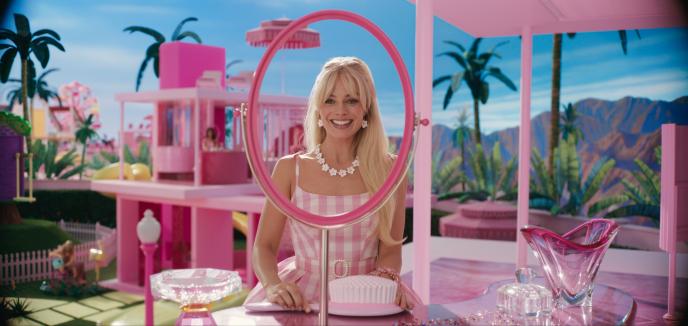 A still from Barbie showing Margot Robbie looking into a fake mirror in the Barbie dreamhouse.