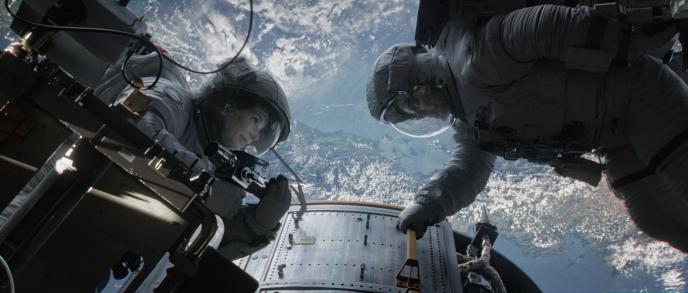 A Still from the film Gravity showing two astronauts in space above the earth.