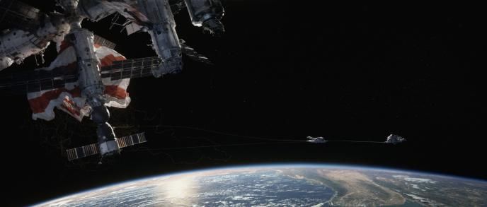A Still from the film Gravity showing two astronauts in space above the earth.